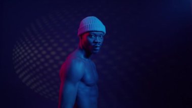 Mavi ışıklandırmayla bağlantılı çıplak gövdeli siyah adam..