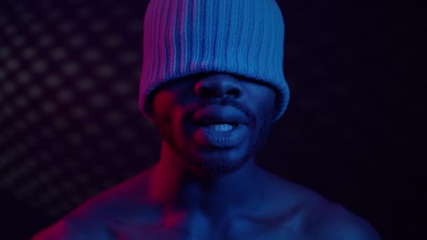 Black Guy In Room With Blue Lighting. On His Head Cap That Closes His Eyes. — Stock Video