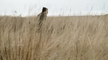 Tarlada koşan iki arkadaş. Zıplarlar ve birbirlerine yetişirler..