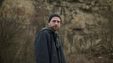 Doğada Duran Şık Genç Adam. Arkasında kaya var..