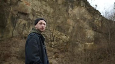 Doğada Duran Şık Genç Adam. Arkasında kaya var..