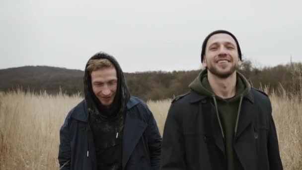 Two Young Guys Walking On The Road In Nature. They Joke And Laugh. — Stock Video