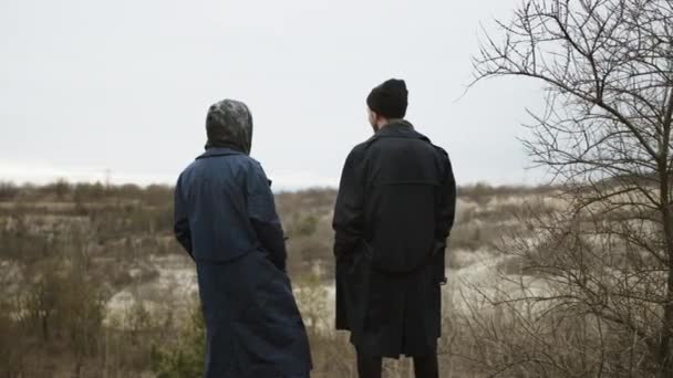 Twee vrienden staan op een heuvel in de natuur. Uitzicht vanaf de achterkant. — Stockvideo