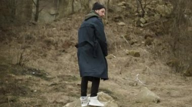 Doğadaki genç şık adam. Büyük Kaya 'ya atlıyor..