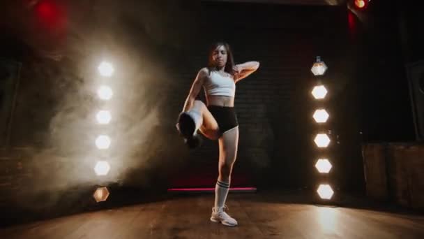 Flicka som dansar twerk i studion. Ung Brunett i shorts och topp. — Stockvideo