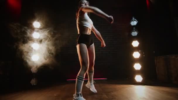 Flicka som dansar twerk i studion. Ung Brunett i shorts och topp. — Stockvideo