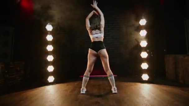 Hezká bruneta tančící twerk ve studiu s blikajícím světlem. — Stock video