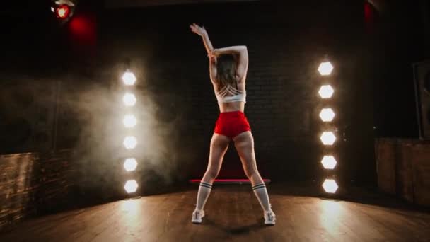 Hezká bruneta tančící twerk ve studiu s blikajícím světlem. — Stock video