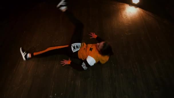 Giovane bruna danza break in studio. Ragazza gira sul pavimento sulla schiena. — Video Stock