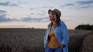 Buğday tarlasında hamile kalmış orta yaşlı bir kadının resmi. Durdu ve uzaklığa baktı. Karanlık çöktüğünde.