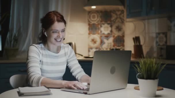 Kvinnan i köket med laptop. Hon ler. — Stockvideo