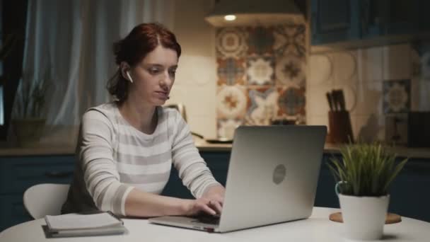 ノートパソコン付きキッチンの女性。彼女は彼女のラップトップを閉じ、キッチンを残します. — ストック動画