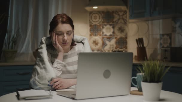 Donna in cucina con computer portatile. Si addormenta seduto vicino al computer portatile. — Video Stock