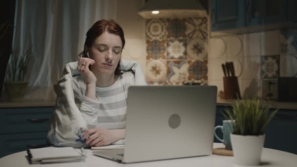 ノートパソコン付きキッチンの女性。彼女はノートパソコンの近くに座って眠る滝. — ストック動画