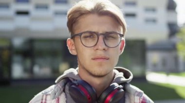Sokaktaki Genç Adamın Portresi. Boynunda kulaklık ve gözlüklü yakışıklı bir adam..