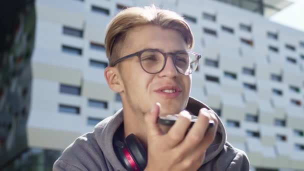 젊은 남자가 거리에서 폰을 들고 있다. 안경을 쓴 귀여운 금발의 남자 (Cute Blond Guy With Glasses) 는 폰을 사용 한다. 그는 맹세 한다. — 비디오