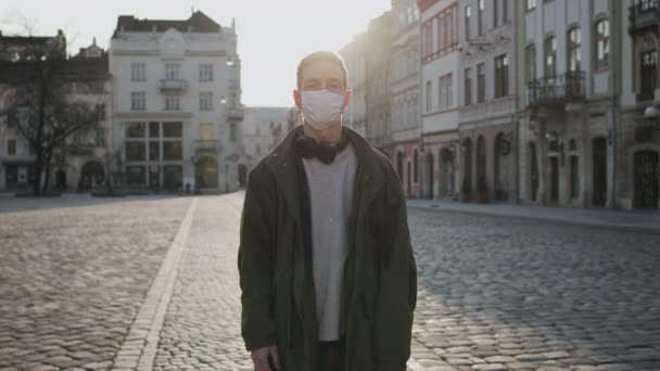 Un joven con máscara médica parado en la calle vacía. Protección contra Epidemias en Guarantina — Vídeo de stock