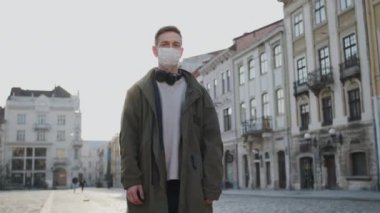 Yüzünde tıbbi maske olan genç bir adam. Salgında Sağlığı Korumak. Boş Sokakta Duran Adam.