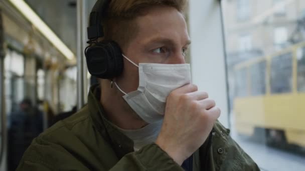 Fiatal fickó buszozik orvosi maszkkal az arcán. Egészségvédelem egy járványban. Guy köhögés. — Stock videók