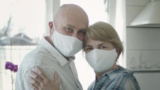Retrato de casal maduro em máscaras médicas em guarantine. Eles abraçam. — Vídeo de Stock