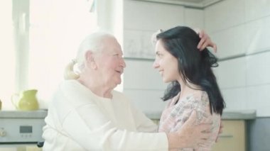 Yaşlı kadın küçük torununa sarılıyor. Mutfaktaki kadın. Kadınlar Konuşuyor.