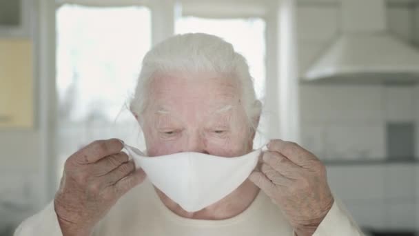 Vecchia donna mette su maschera per la protezione durante l'epidemia di infezione virale. — Video Stock