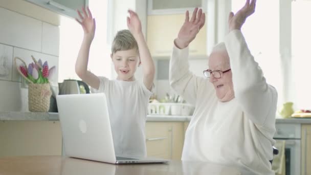 Una vecchia donna e il suo pronipote usano il computer portatile. — Video Stock