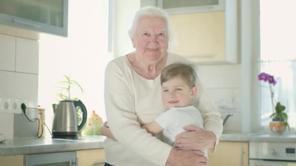 Alte Frau umarmt ihren Urenkel. — Stockvideo