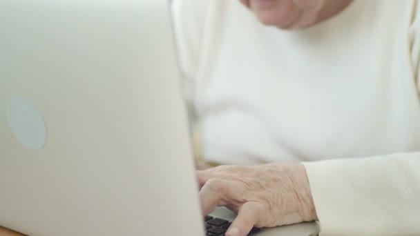 Gözlüklü gri saçlı büyükanne bilgisayarın ekranına dikkatle bakıyor.. — Stok video