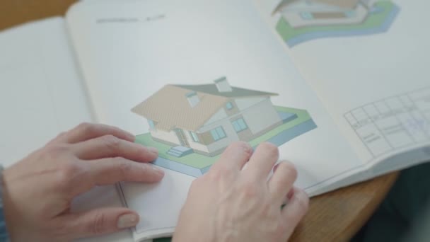 Mãos de mulher mostrando desenhos da casa em desenhos. — Vídeo de Stock