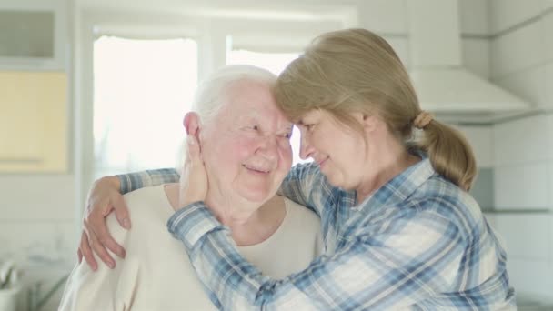 Porträt zweier Frauen. Tochter umarmt ihre alte Mutter. Frauen in der Küche. — Stockvideo