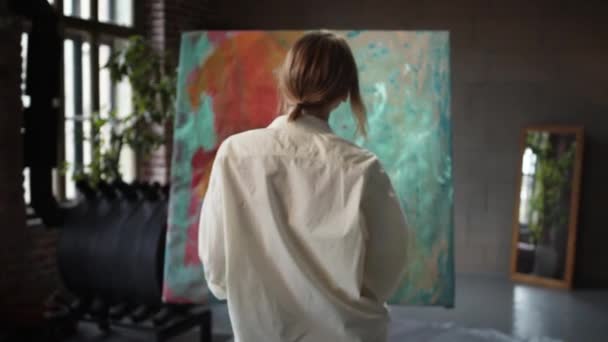 Ragazza artista approcci la pittura e spray vernice dal pennello. — Video Stock