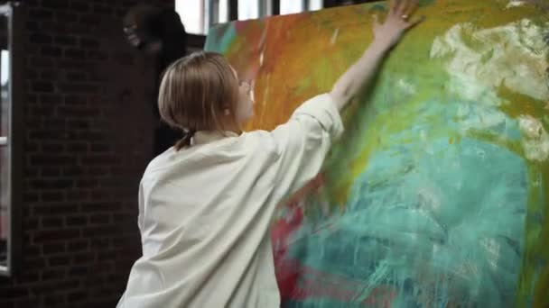 Giovane artista dipinge immagine in uno studio d'arte. Ragazza disegna con la sua mano. — Video Stock