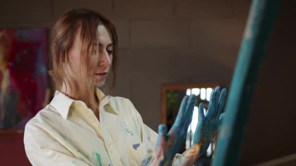 Girl Artist In Art Studio. She Looks At Her Hands Soaked In Paint. — Stock Video