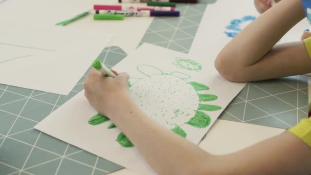 Kinderhände zeichnen Zeichnungen, die am Tisch sitzen. Bild Nahaufnahme. Junge zeichnet Blume. — Stockvideo