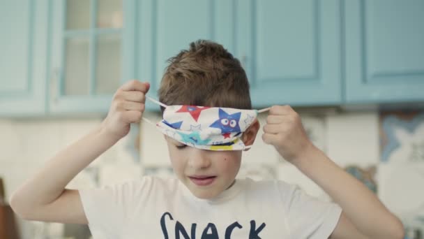 Pojke bär medicinsk mask. Mask med flerfärgade stjärnor. — Stockvideo