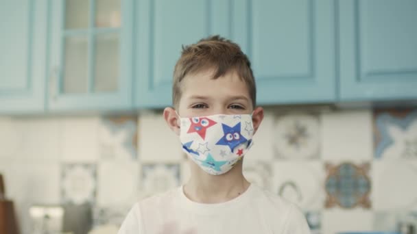 Porträt eines Jungen in bunter medizinischer Maske. — Stockvideo