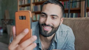 Genç adam cep telefonuyla video bağlantısı üzerinden biriyle konuşuyor..