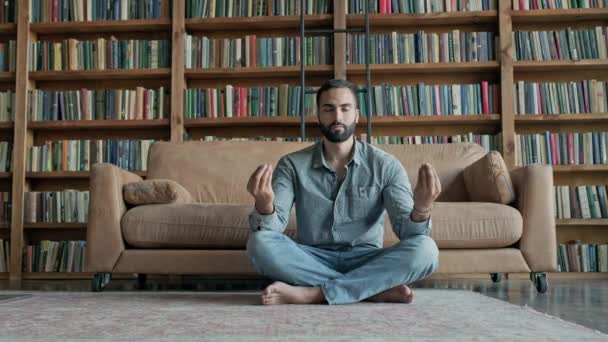 A fiatalember meditál a könyvtárban.. — Stock videók