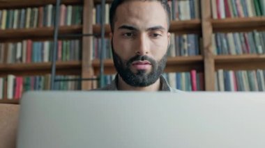 Doğu 'dan gelen genç adam dizüstü bilgisayarla koltukta oturuyor..