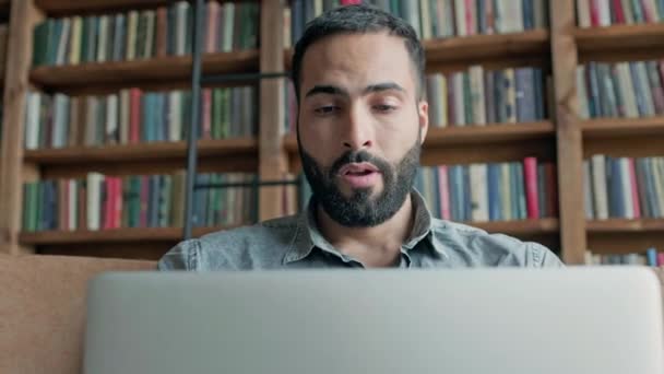 Cansado jovem trabalhando no laptop na biblioteca. — Vídeo de Stock