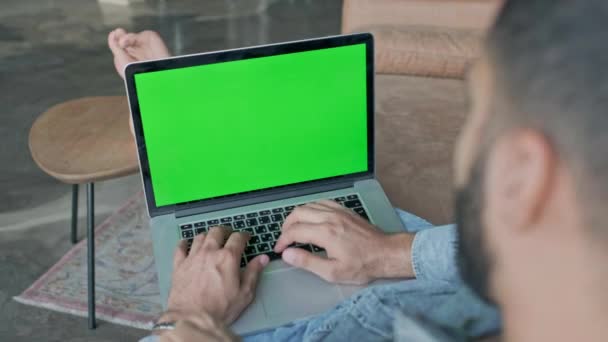 Barfota ung man sitter i avslappnad ställning med laptop. — Stockvideo