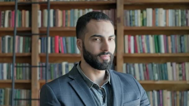 Ragazzo da est sullo sfondo di scaffali con libri. — Video Stock