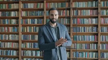 Rafların arkasında kitaplarla birlikte doğudan gelen adam..