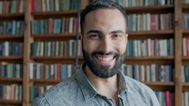 Rafların arkasında kitaplarla birlikte doğudan gelen adam..