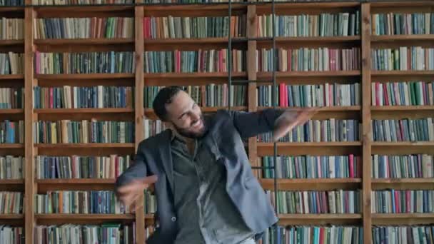 Гай з "являється в бібліотеці і щасливо пересуває руки. — стокове відео