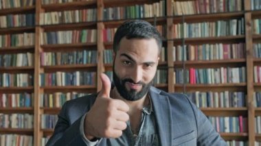 Kütüphanedeki şık adam eliyle her şeyin yolunda olduğunu gösteriyor..