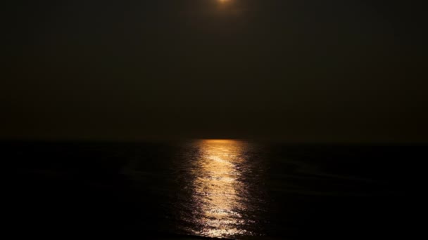 Buenas noches. Reflejo de la luna en el agua del océano. — Vídeo de stock