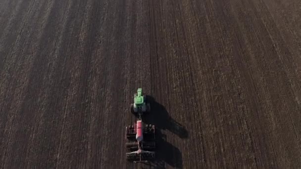 Vista aerea dei campi di raccolta. Trattore guida attraverso il campo — Video Stock