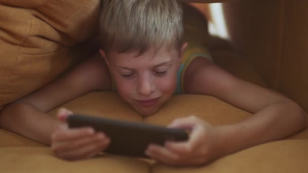 Niño jugando emocionalmente juego en el teléfono móvil. — Vídeos de Stock